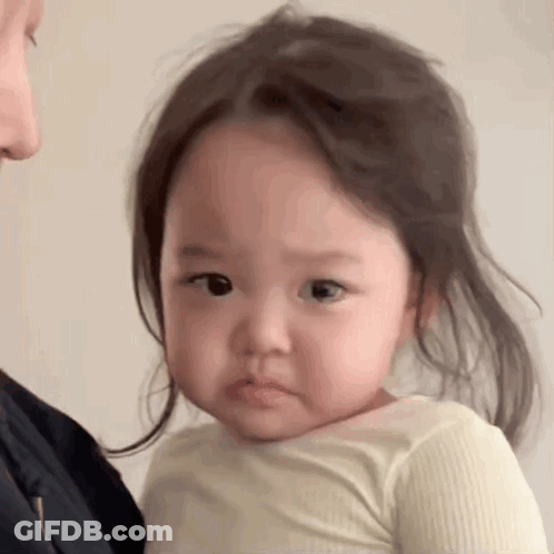 Little Girl Making Funny Face Held By Woman GIF
