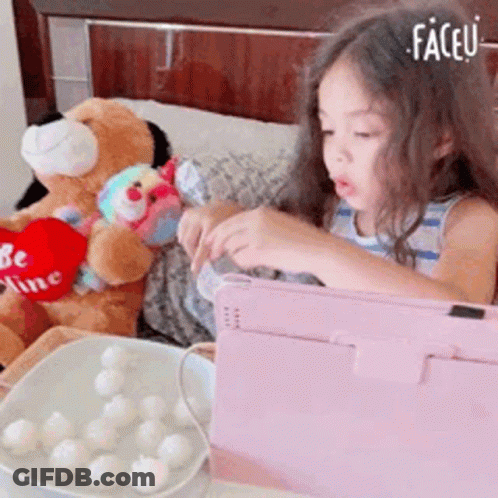 Little Girl Playing Tablet Next To Teddy Bear Saying Be Mine GIF