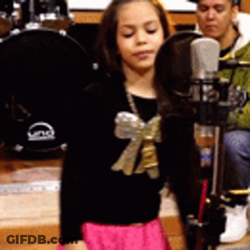 Little Girl Singing Into Microphone With Bow GIF