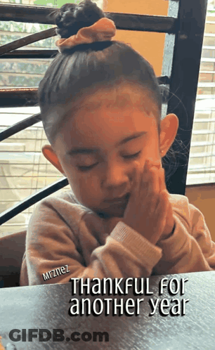 Little Girl Sitting At Table Thankful For Another Year GIF