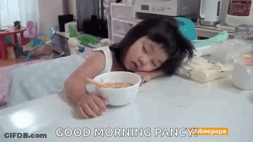 Little Girl Sitting At Table With Bowl Of Cereal GIF