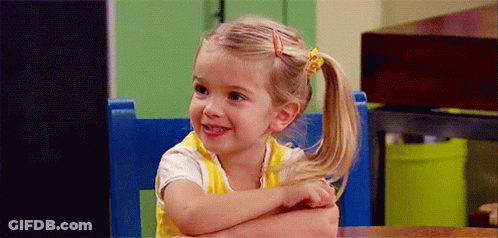 Little Girl Sitting In Blue Chair Arms Crossed Smiling GIF