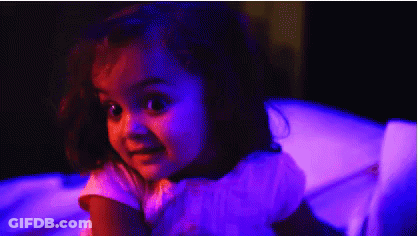 Little Girl Sitting In Chair With Purple Lights GIF