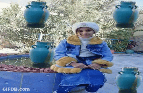Little Girl Sitting In Front Of Fountain GIF