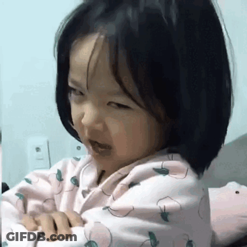 Little Girl Sitting On Bed Making Funny Face GIF