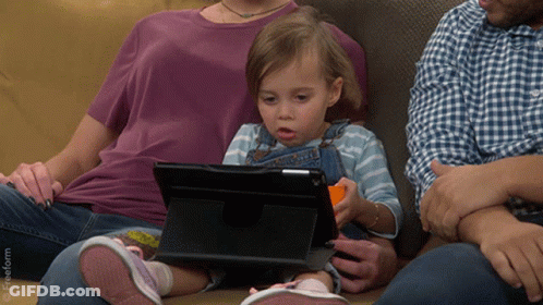 Little Girl Sitting On Couch Looking At Tablet With Freeform Logo GIF