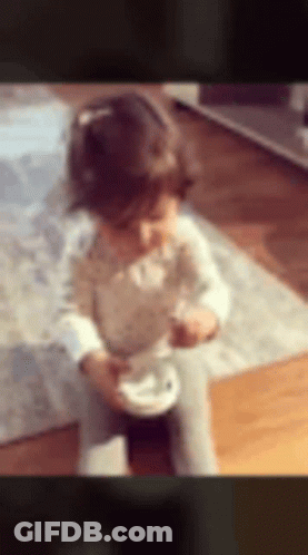 Little Girl Sitting On Floor Eating GIF