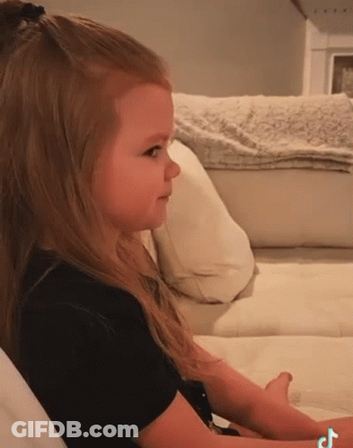 Little Girl Sitting On White Couch With TikTok Logo GIF
