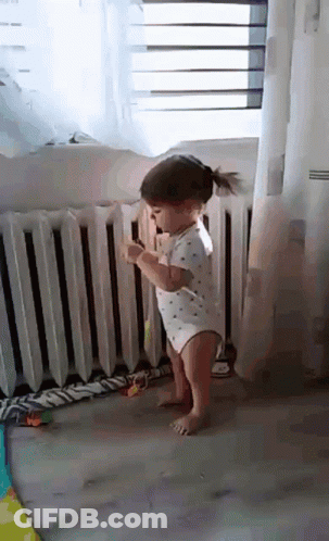 Little Girl Standing In Front Of Radiator GIF