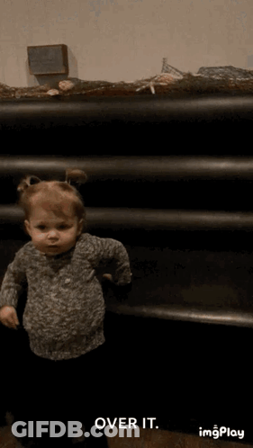 Little Girl Standing In Front Of Shelf GIF