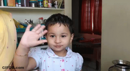 Little Girl Waving Hand In Room GIF
