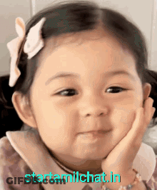 Little Girl With Bow Smiling Hand On Chin GIF