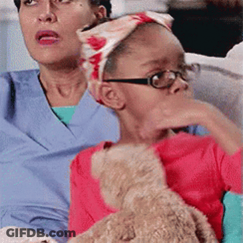 Little Girl With Glasses Holding Teddy Bear Beside Woman GIF