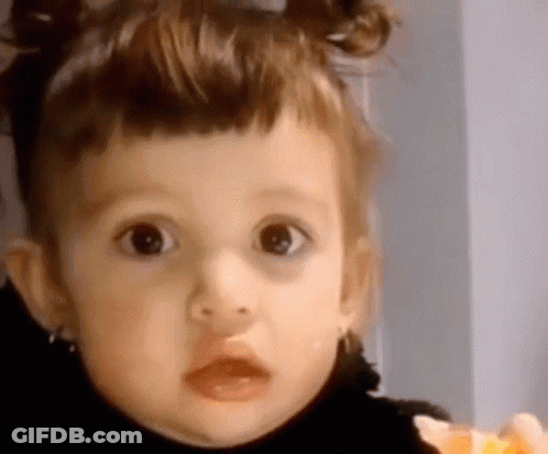 Little Girl With Pigtails Looking At Camera GIF