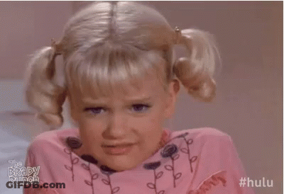 Little Girl With Pigtails Making Funny Face In Pink Shirt GIF