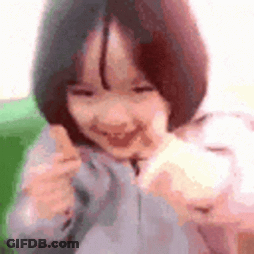 Little Girl With Short Hair Smiling Holding White Object GIF