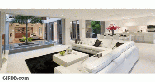 Living Room With White Sectional Couch And Coffee Table GIF