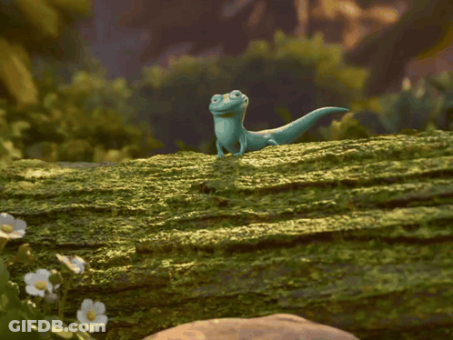 Lizard Standing On Mossy Log With Tongue Out GIF