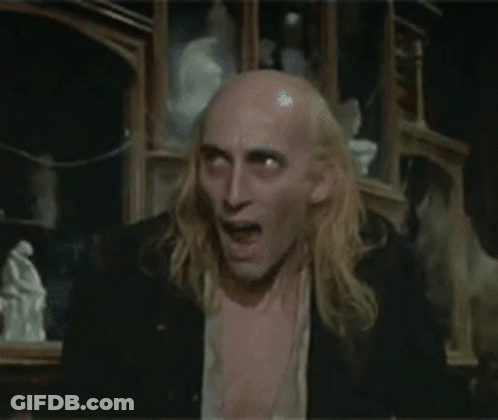 Long Blonde Hair Bald Man Shirtless In Dark Room GIF