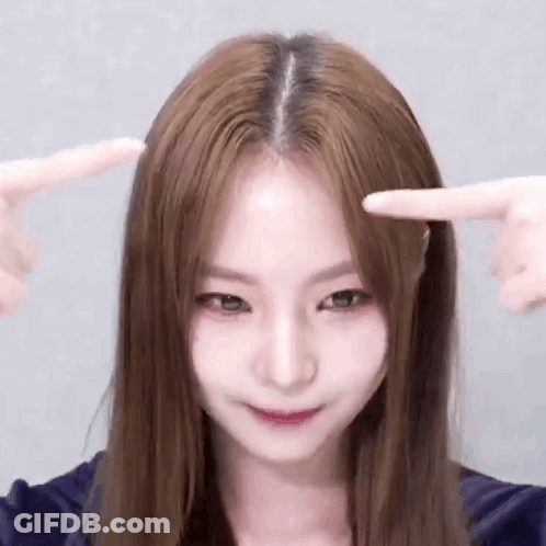 Long Brown Haired Woman Pointing At Forehead GIF