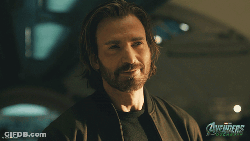 Long Hair Beard Man Smiling In Front Of Avengers Age Of Ultron Poster GIF