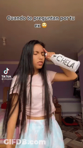 Long Haired Girl Holding Chela Bottle Over Head GIF