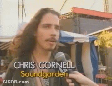 Long-Haired Man Holding Chris Cornell Mic GIF