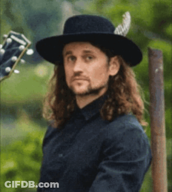 Long Haired Man In Black Hat Holding Guitar Willin GIF