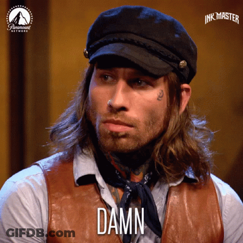 Long Haired Man In Hat And Vest Saying Damn GIF
