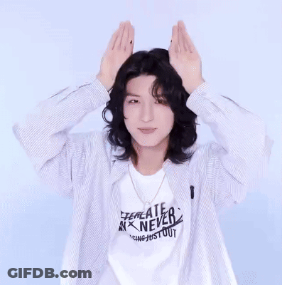 Long Haired Man In Striped Shirt Making Heart GIF