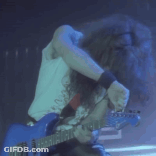 Long Haired Man Playing Blue Guitar In Dark Room GIF