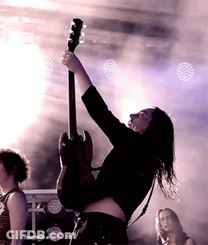 Long-Haired Man Playing Guitar On Stage GIF