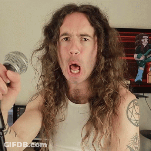 Long Haired Man Singing Into Microphone With Arm Tattoo GIF