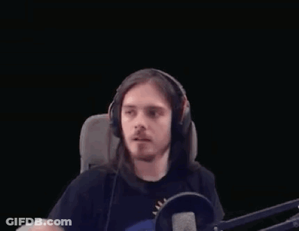 Long-Haired Man With Headphones Making Heart At Microphone GIF