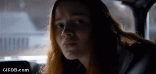 Long Red-Haired Woman In Car Looking At Camera GIF