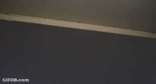 Looking Up At A Very Tall Building With A Cloudy Sky In The Background GIF