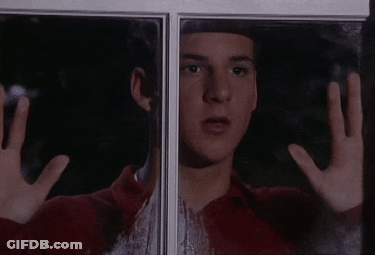 Love Struck Guy Stalking Behind Glass GIF