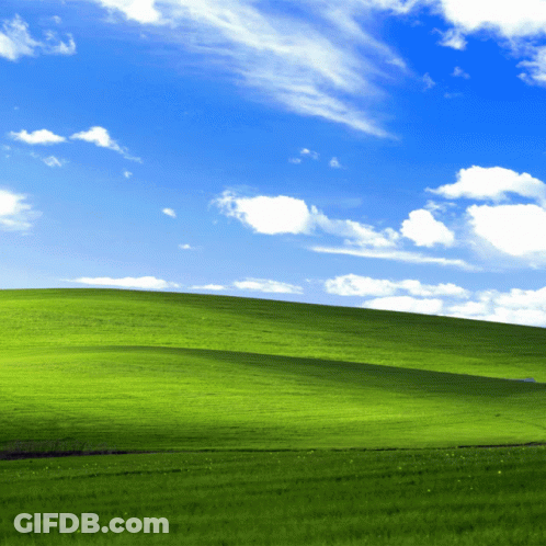 Lush Green Hillside With Blue Sky And White Clouds GIF