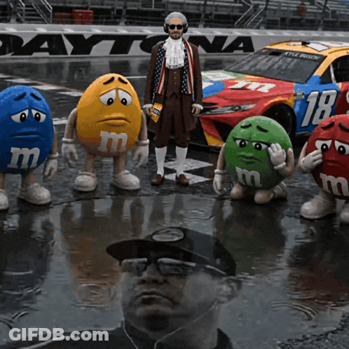 M&Ms Standing In Front Of Daytona Race Car GIF