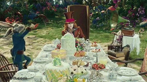 Mad Hatter Sitting At Table With Cakes GIF