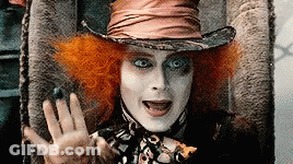 Mad Hatter Sitting In Chair With Hand Out GIF