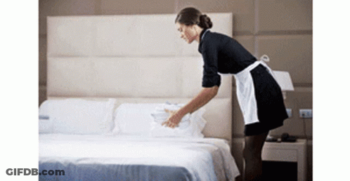 Maid In Apron Making Bed In Hotel Room GIF