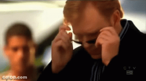 Man Adjusting Glasses Behind Woman GIF