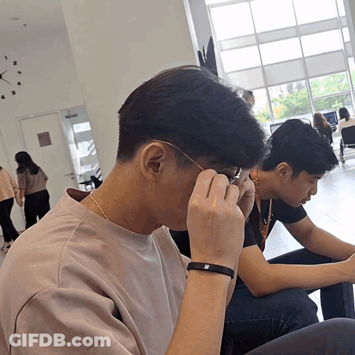 Man Adjusting Glasses Beside Clock Saying A GIF