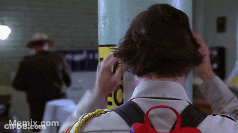 Man Adjusts Hair Near EC Sign GIF