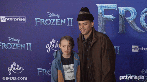 Man And Boy Posing In Front Of Disney Frozen II Poster GIF