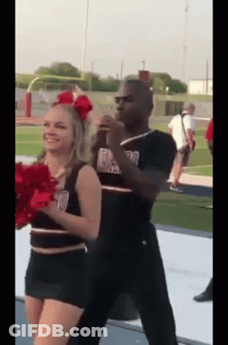Man And Cheerleader Dancing On Football Field GIF