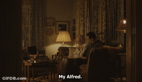 Man And Elderly Woman With Photo Album Saying But He Got Bit By Animal GIF