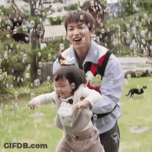 Man And Girl Playing With Soap Bubbles GIF