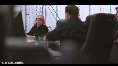 Man And Woman At Desk With Numbered Wall GIF